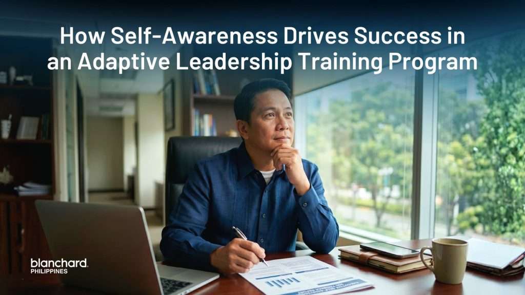 A corporate leader sits thoughtfully at his desk looking out a window, reflecting on his leadership style as part of a situational leadership training program focused on self-awareness.